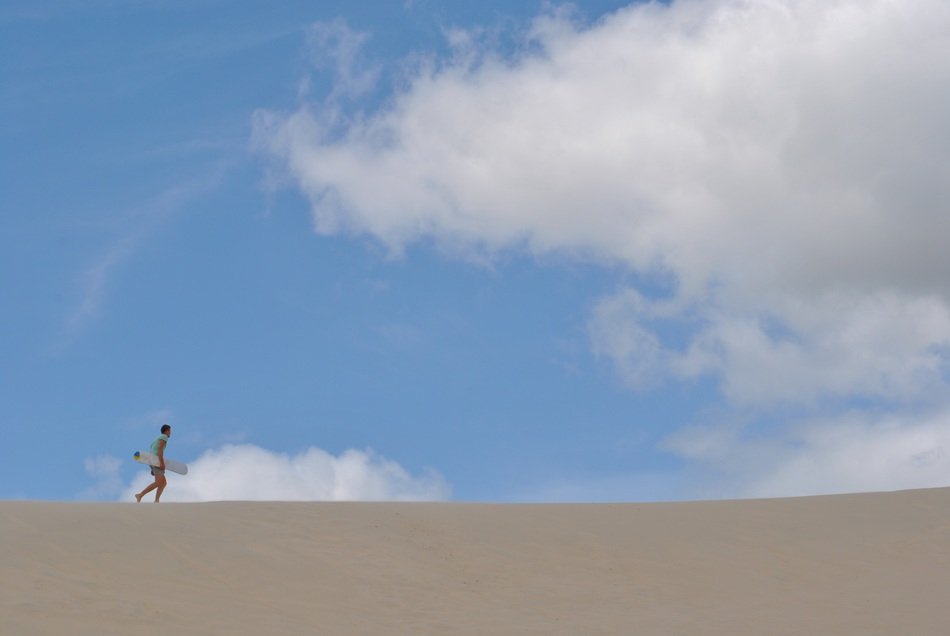 man with sandboard in the sand