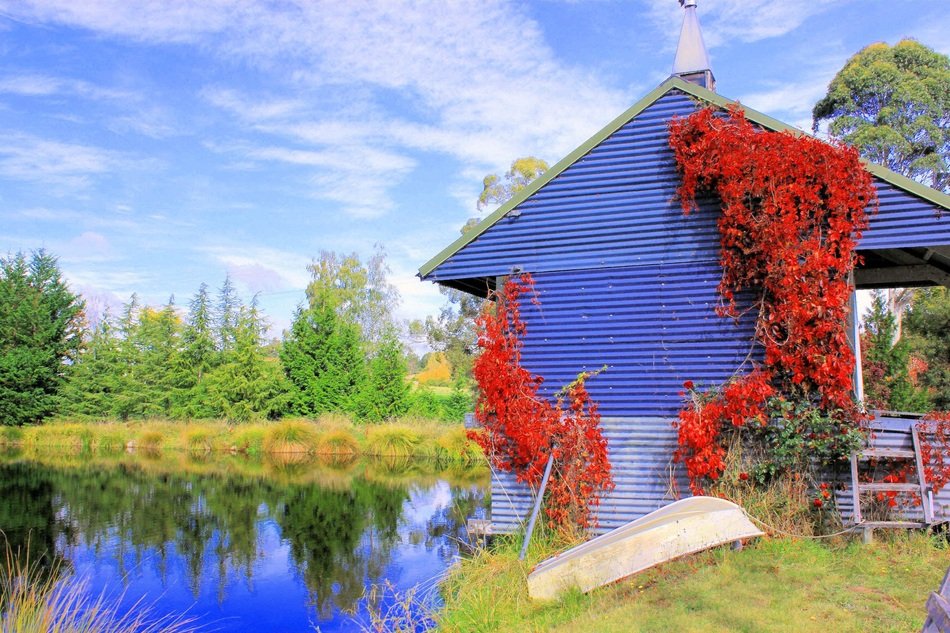 blue boathouse on a lake on a south island in new zealand