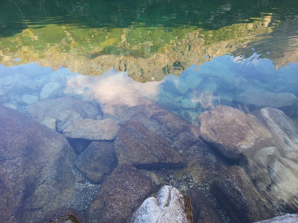 a reflection of the rocks in the lake
