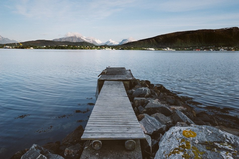 wooden bridge near the water in the mountains