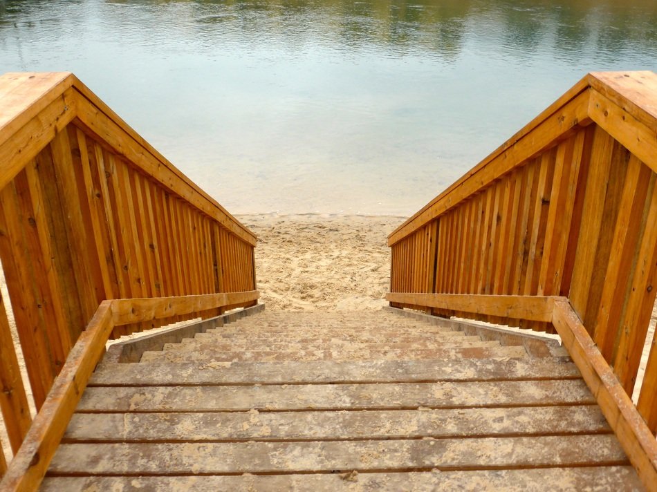 staircase with wooden rails near water
