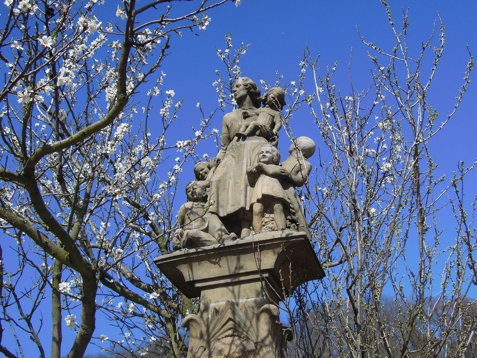 mother with children like a stone statue among trees