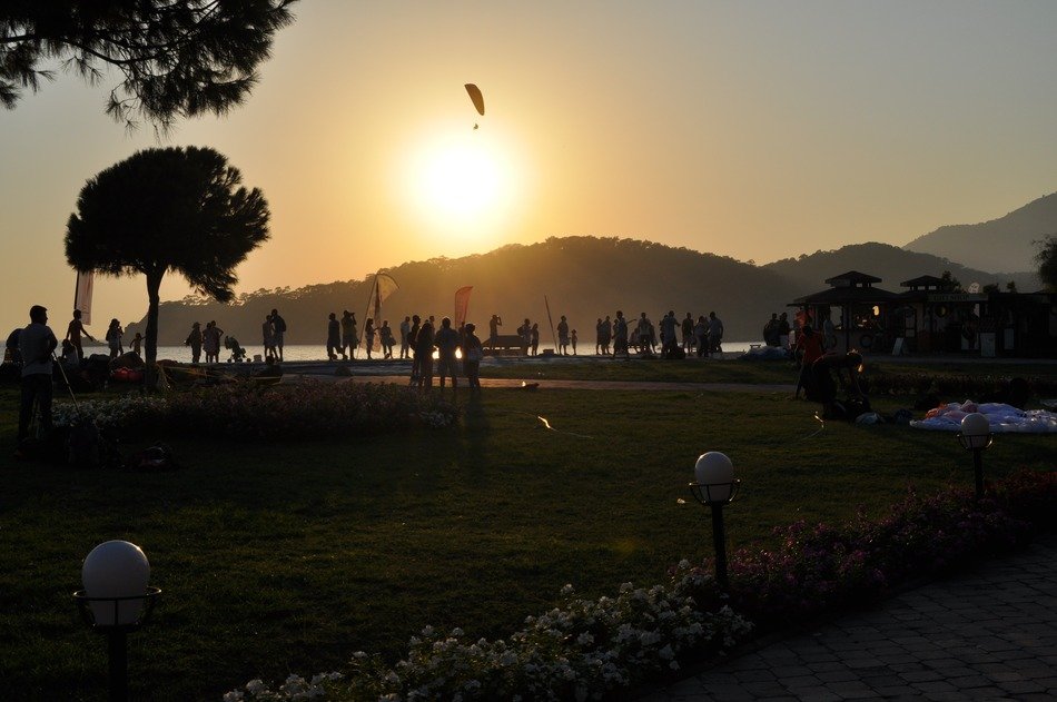 People near the natural sea during sunset