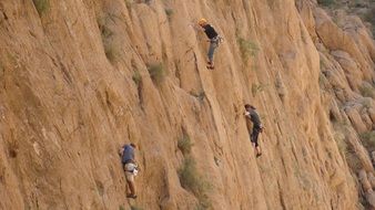 climbers on high brown rock