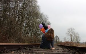 Girl with balloons on the rails