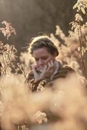 young caucasian girl sitting on autumn meadow, head down