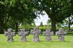 five stone crosses on green grass