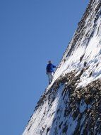 man climbing snowy mountain