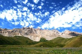 mountains under a blue sky with clouds in Kyrgyzstan