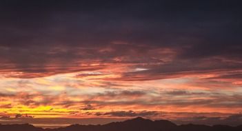 dark clouds in the sky with a pink glow during sunset