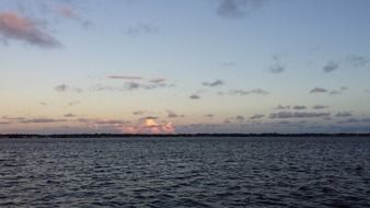 sunset on the horizon above the river at dusk