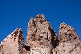three red rocks side by side at blue sky