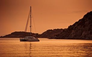 Boat on the water near the mountain at dusk