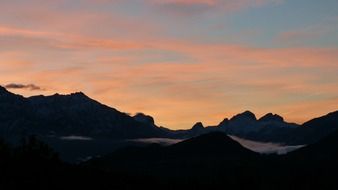 Beautiful, pink and orange sunrise over majestic mountains in shadow