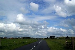 flat asphalt road among the fields of normandy
