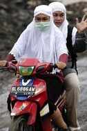 two women in Hijabs riding motorcycle, indonesia, sumatra