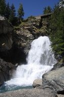 waterfall on a rock under the blue sky