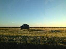 the barn stands in the middle of a green field