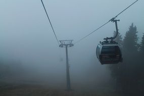 mountain cableway in foggy landscape