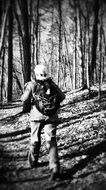 female hiker with backpack in forest