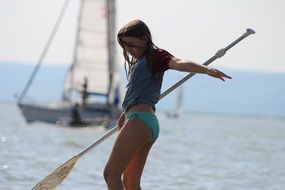 girl with a paddle on a boat in the lake