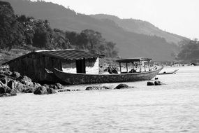 black and white photo of a hut and a fishing boat