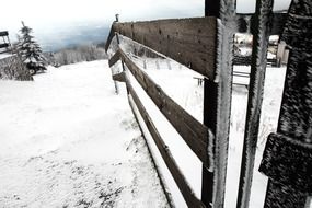 fence along a pasture on a hill in winter