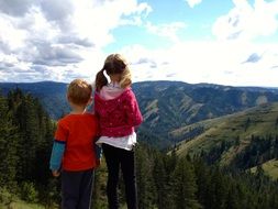 child girl and boy looking at scenic mountain landscape