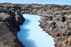 picturesque blue lagoon in dark rocks, iceland
