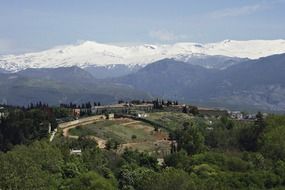 farm fields on a hill against the backdrop of the Sierra Nevada mountain range