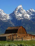 Mormon row barn in National park at beautiful snowy mountains background