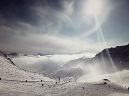 chair lift and skiing people on snowy mountain side