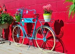 plant holder blue bicycle decoration near Red wall