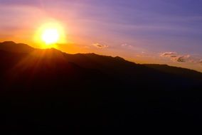 bright sunlight over the silhouettes of mountains