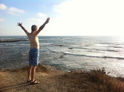man is standing on ocean coast