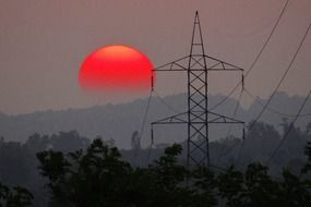 dramatic red sunset with electric pylon tower