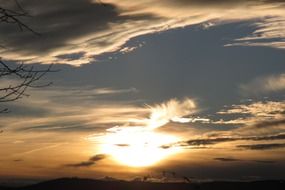 bright sunset behind white clouds