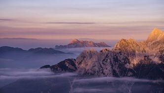 mountain peaks over clouds at sunset
