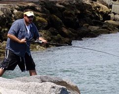 fisherman holding rod at water