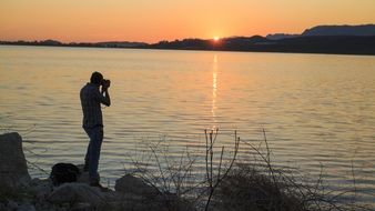 man takes pictures of the sunset