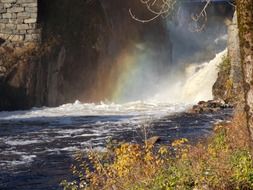 gorgeous waterfall with rainbow in norway