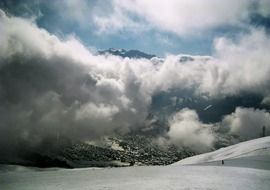 thick white clouds over the snowy alps