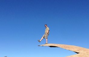 man balancing on a chip rock