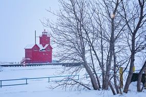 red lighthouse in the winter snow