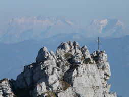 cross on the top of a mountain on the background of mountain scenery in the mist