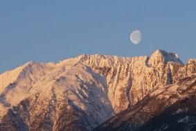 moon in the blue sky over the mountain