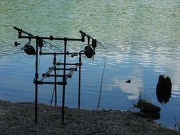 fishing rods near the beautiful lake with plants