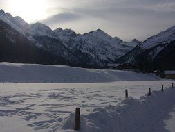 Evening on a beautiful snowy field on a background of snowy mountains