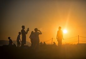 silhouettes of people on the background of the bright sun