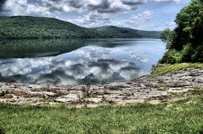 reflection of gray clouds in a lake on a forest background